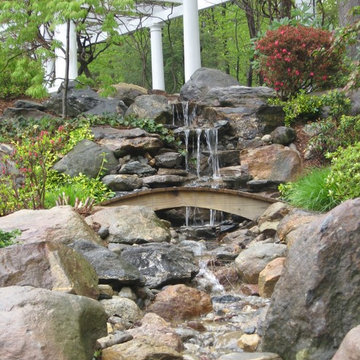 Rock waterfall on a slope with a pergola in Connecticut