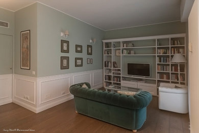 Immagine di un piccolo soggiorno tradizionale aperto con libreria, pareti verdi, parquet chiaro, TV autoportante e pavimento marrone