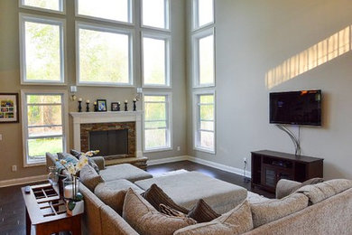 Living room - traditional open concept medium tone wood floor living room idea in Cleveland with beige walls, a standard fireplace, a wood fireplace surround and a wall-mounted tv