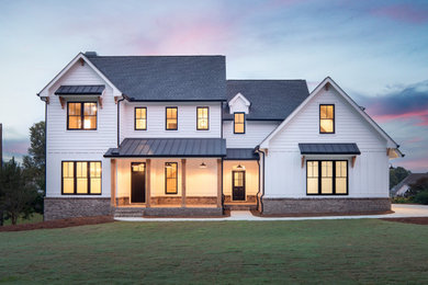This is an example of a country two-storey white house exterior in Atlanta with a gable roof, a mixed roof, a grey roof, board and batten siding and clapboard siding.