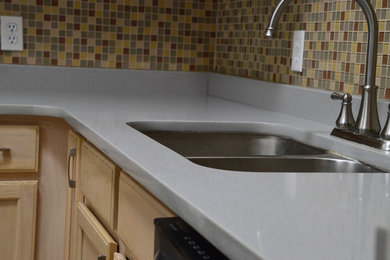 Small trendy u-shaped porcelain tile kitchen pantry photo in Albuquerque with an undermount sink, beaded inset cabinets, light wood cabinets, quartz countertops, beige backsplash, mosaic tile backsplash, stainless steel appliances and no island
