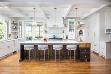 Mid-sized elegant single-wall medium tone wood floor, brown floor and exposed beam open concept kitchen photo in Raleigh with an undermount sink, shaker cabinets, white cabinets, quartzite countertops, gray backsplash, marble backsplash, stainless steel appliances, an island and white countertops