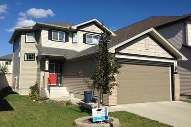 Example of a mid-sized beige two-story vinyl exterior home design in Calgary
