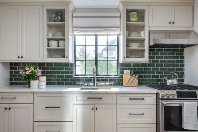 Example of a mid-sized transitional galley medium tone wood floor and brown floor enclosed kitchen design in New York with an undermount sink, shaker cabinets, quartz countertops, green backsplash, subway tile backsplash, stainless steel appliances, no island and white countertops