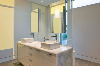 Bathroom - large contemporary master white tile beige floor and ceramic tile bathroom idea in Tampa with flat-panel cabinets, white cabinets, white walls, a vessel sink, quartz countertops and a two-piece toilet