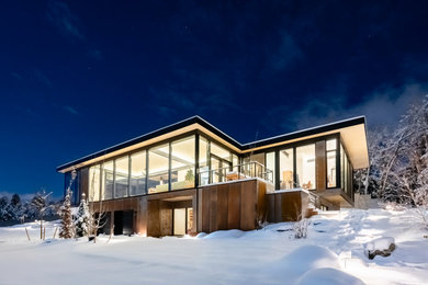 Inspiration for a large mid-century modern gray two-story metal flat roof remodel in Denver with a black roof