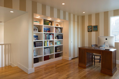 Home office library - large transitional freestanding desk medium tone wood floor home office library idea in San Francisco with multicolored walls