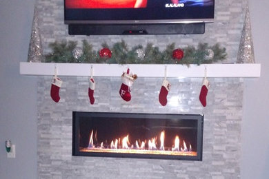 Mid-sized trendy open concept dark wood floor and brown floor family room photo in Chicago with gray walls, a ribbon fireplace, a stone fireplace and a wall-mounted tv