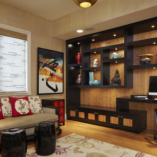 This is an example of a medium sized world-inspired home office and library in Miami with medium hardwood flooring, a built-in desk, beige walls and no fireplace.