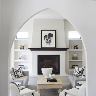 Großes, Offenes Mediterranes Wohnzimmer mit weißer Wandfarbe, Kamin, verputztem Kaminsims, dunklem Holzboden und braunem Boden in Minneapolis