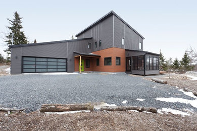 Diseño de fachada de casa gris minimalista grande de dos plantas con revestimientos combinados, tejado de un solo tendido y tejado de metal