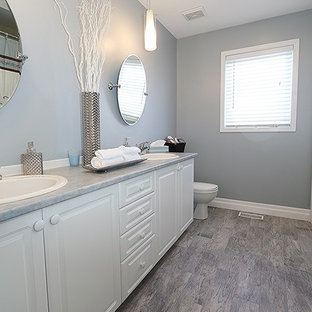 Idee per una stanza da bagno con doccia minimalista di medie dimensioni con pareti grigie, parquet chiaro, ante bianche, WC monopezzo, ante con bugna sagomata e lavabo da incasso