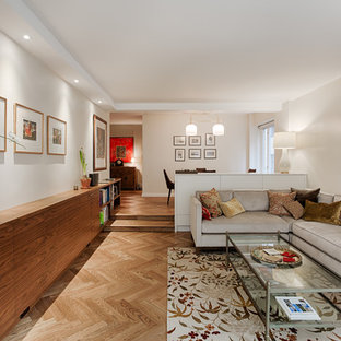 Bild på ett funkis allrum med öppen planlösning, med ett finrum, beige väggar, mellanmörkt trägolv, en dold TV och brunt golv