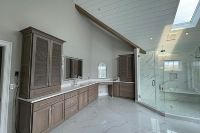 Bathroom - large transitional master white tile and stone tile marble floor, white floor, double-sink, exposed beam and shiplap wall bathroom idea in Philadelphia with louvered cabinets, brown cabinets, a one-piece toilet, gray walls, an undermount sink, quartzite countertops, a hinged shower door, white countertops and a built-in vanity