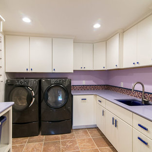 バーリントンの大きいコンテンポラリースタイルのおしゃれな洗濯室 (アンダーカウンターシンク、フラットパネル扉のキャビネット、白いキャビネット、人工大理石カウンター、紫の壁、左右配置の洗濯機・乾燥機、紫のキッチンカウンター) の写真