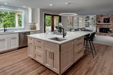 Example of a mid-sized classic l-shaped light wood floor and brown floor kitchen design in Seattle with a double-bowl sink, shaker cabinets, light wood cabinets, quartz countertops, beige backsplash, ceramic backsplash, stainless steel appliances, an island and white countertops
