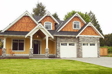 Design ideas for a large arts and crafts two-storey yellow exterior in Vancouver with mixed siding and a gable roof.