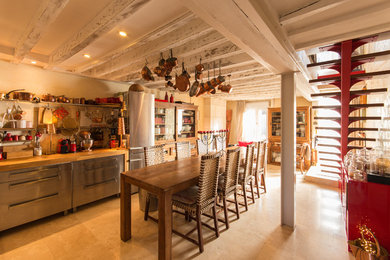 Aménagement d'une grande cuisine ouverte linéaire campagne en bois brun avec un placard sans porte, un plan de travail en bois, une crédence beige et une crédence en travertin.