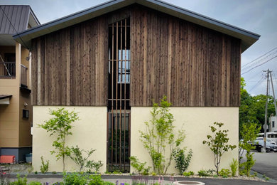 Imagen de fachada de casa negra pequeña de dos plantas con revestimiento de madera, tejado a dos aguas, tejado de metal y panel y listón