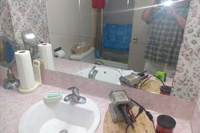 Mid-sized elegant 3/4 pink tile and matchstick tile linoleum floor and beige floor bathroom photo in Seattle with raised-panel cabinets, distressed cabinets, a one-piece toilet, multicolored walls, a drop-in sink, laminate countertops and pink countertops
