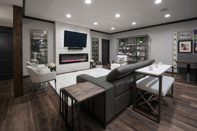 Inspiration for a large craftsman underground laminate floor basement remodel in Indianapolis with gray walls and a stone fireplace