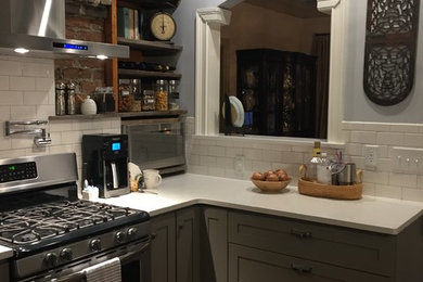 This is an example of a traditional kitchen in Nashville with a farmhouse sink, shaker cabinets, grey cabinets, quartz benchtops, white splashback, subway tile splashback, stainless steel appliances and medium hardwood floors.