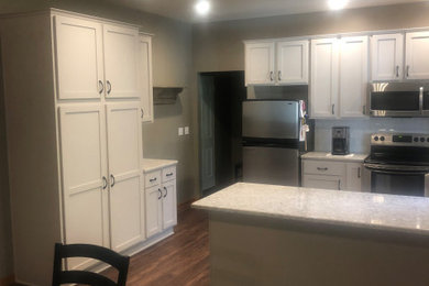 Mid-sized minimalist l-shaped eat-in kitchen photo in Other with shaker cabinets, white cabinets, quartz countertops and subway tile backsplash