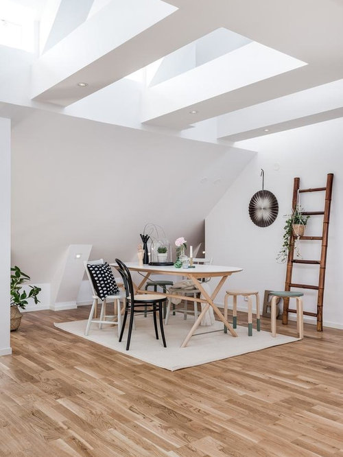 Bild på en stor funkis matplats med öppen planlösning, med vita väggar, mellanmörkt trägolv och brunt golv