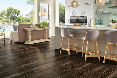 Open concept kitchen - mid-sized contemporary galley dark wood floor and brown floor open concept kitchen idea in Vancouver with flat-panel cabinets, white cabinets, quartzite countertops, green backsplash, stainless steel appliances and an island