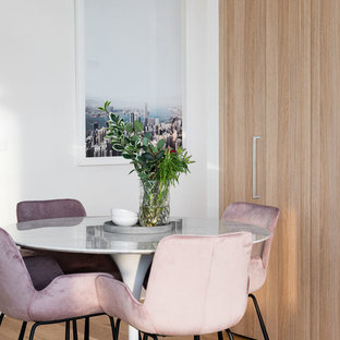 Contemporary dining room in Melbourne with white walls, medium hardwood floors and brown floor.