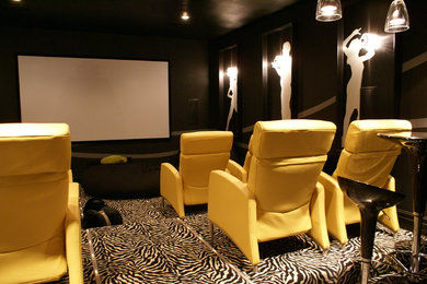 This is an example of a mid-sized midcentury open concept home theatre in Little Rock with black walls, carpet and a projector screen.