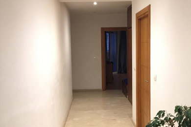 Exemple d'un couloir tendance de taille moyenne avec un mur blanc, un sol en calcaire et un sol beige.