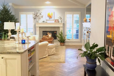 This is an example of a mid-sized beach style open concept living room in Jacksonville with blue walls, porcelain floors, a standard fireplace, a wood fireplace surround, no tv and brown floor.