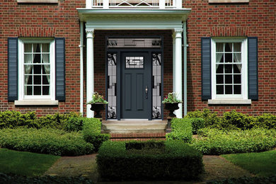 Inspiration for a large timeless red two-story brick exterior home remodel in Toronto