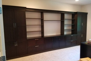 Photo of a mid-sized transitional home office in Detroit with a library, beige walls, carpet and beige floor.