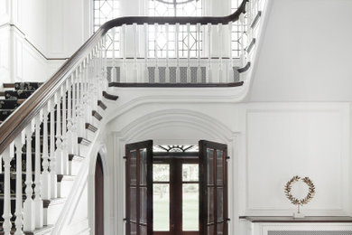 Example of a classic marble floor and multicolored floor entryway design in St Louis with white walls and a dark wood front door