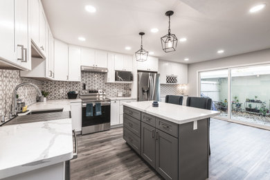 Large minimalist l-shaped vinyl floor and gray floor eat-in kitchen photo in San Francisco with an undermount sink, shaker cabinets, white cabinets, quartz countertops, gray backsplash, mosaic tile backsplash, stainless steel appliances, an island and white countertops