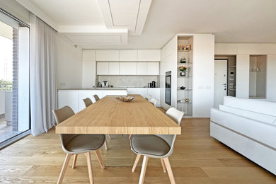 Immagine di una grande sala da pranzo aperta verso la cucina minimalista con pareti bianche, pavimento in legno massello medio, pavimento marrone e soffitto ribassato