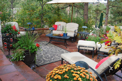 Traditional backyard patio in Denver with natural stone pavers.