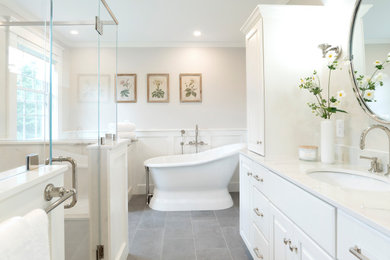 Example of a mid-sized classic master ceramic tile, gray floor, single-sink and wainscoting bathroom design in Burlington with raised-panel cabinets, white cabinets, a two-piece toilet, gray walls, an undermount sink, a hinged shower door, white countertops and a freestanding vanity