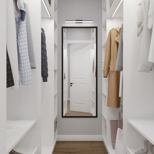 Ejemplo de armario vestidor unisex, escandinavo, pequeño, con armarios abiertos, puertas de armario blancas, suelo marrón y suelo de madera en tonos medios