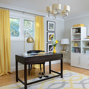 Design ideas for a mid-sized transitional home studio in Toronto with grey walls, bamboo floors, a freestanding desk and brown floor.
