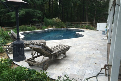 Design ideas for a large traditional backyard custom-shaped lap pool in DC Metro with concrete pavers.