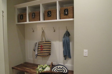 Inspiration for a mid-sized coastal single-wall utility room remodel in Seattle with shaker cabinets, white cabinets, wood countertops, beige walls and brown countertops