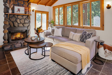 Inspiration for a mid-sized rustic wood ceiling living room remodel in Other with white walls, a standard fireplace, a stone fireplace and a wall-mounted tv