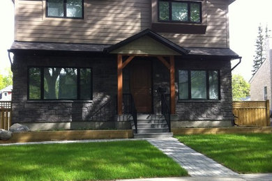 Example of a mid-sized arts and crafts multicolored two-story mixed siding house exterior design in Other with a hip roof and a shingle roof