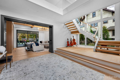 Large transitional wooden floating glass railing staircase photo in Chicago with painted risers