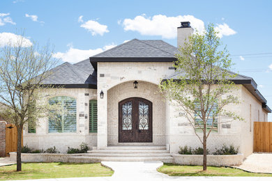 Example of a large classic white one-story brick house exterior design with a hip roof and a shingle roof