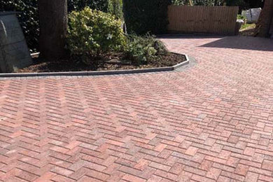 Inspiration for a large modern front driveway garden in Wiltshire with concrete paving.