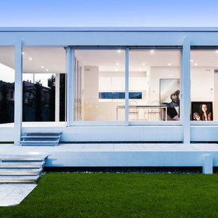 他の地域のコンテンポラリースタイルのおしゃれな家の外観 (ガラスサイディング、陸屋根) の写真